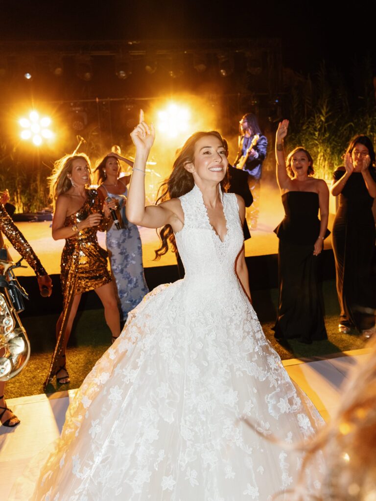A bride dancing in front of the stage as the band plays, Aston Band