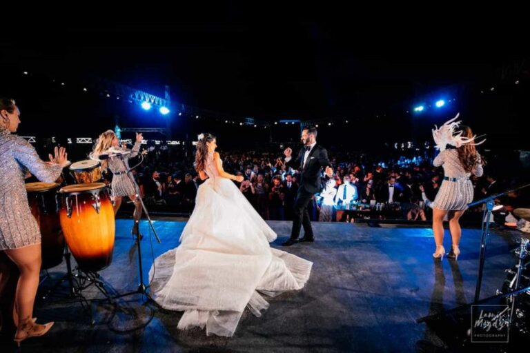 A bride dancing in her gown in front of the stage and band, Aston Band