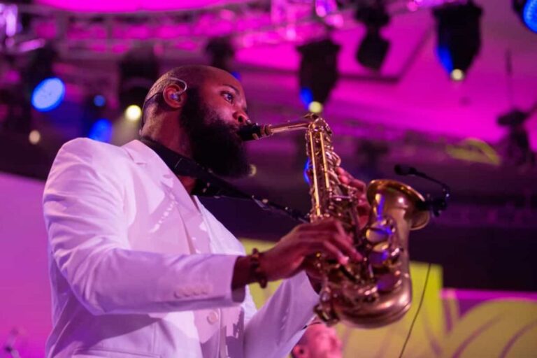 A saxophone solo on stage in pink and magenta light, Aston Band