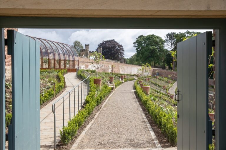 The Walled Garden, a long planted path viewed through the gateway, Auckland Castle
