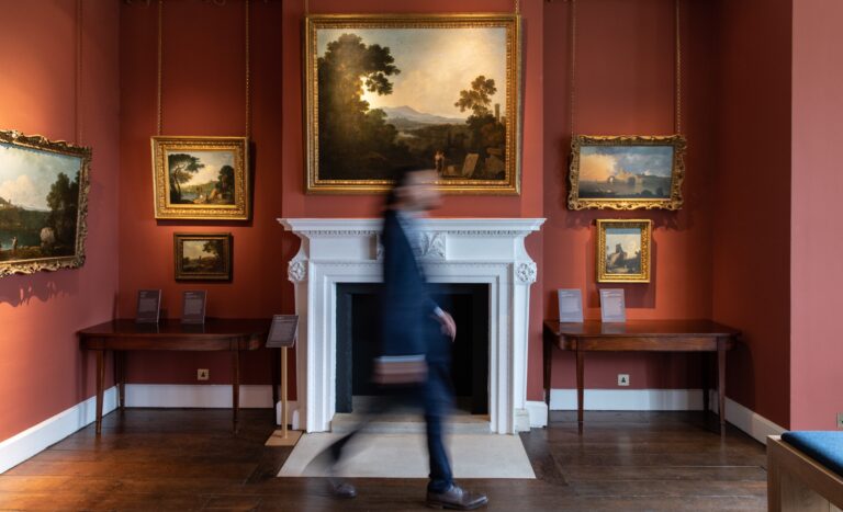 A State Room with deep red walls, a marble fireplace and hung paintings, Auckland Castle