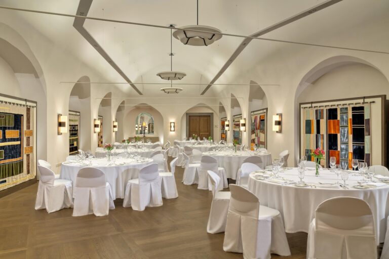 Vaulted hall laid with round tables, Augustine Hotel, Prague