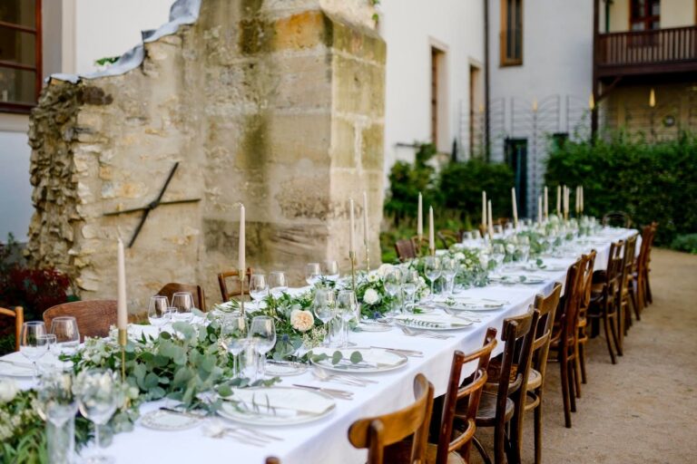 Long table laid outdoors beside historic stone walls, Augustine Hotel, Prague