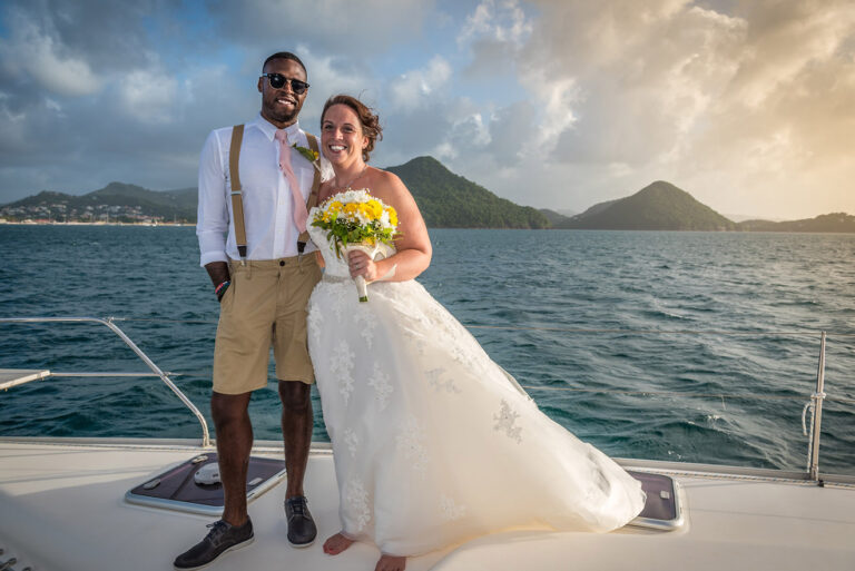 Couple on a yacht deck in front of a green coastline, Awesome Caribbean Weddings