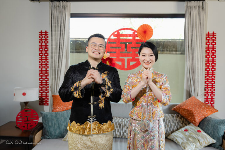 Couple in traditional Chinese wedding dress beside double happiness symbols, Bali, Axioo Bali