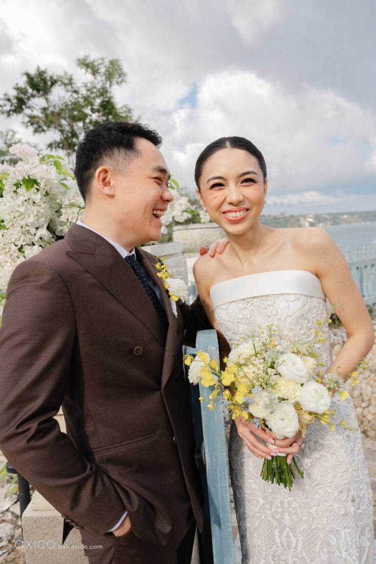 Bride and groom laughing together with a yellow and white bouquet, Jumeirah Bali, Axioo Bali
