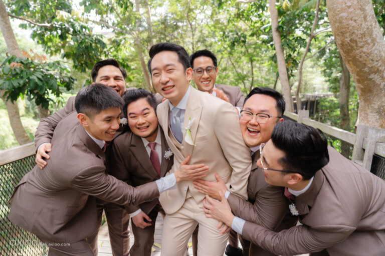 Groom laughing among his groomsmen in a wooded garden, Bali, Axioo Bali