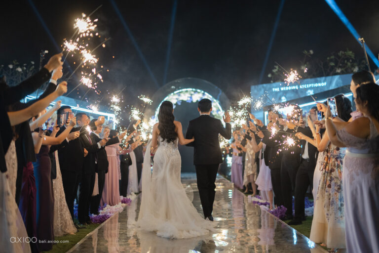 Couple walking through a sparkler send-off lined by guests at night, Bali, Axioo Bali