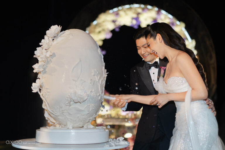 Couple cutting a sculpted white cake at the reception, Bali, Axioo Bali