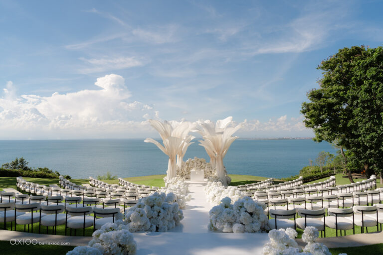 Clifftop ceremony set with pampas arrangements and white chairs above the sea, Bali, Axioo Bali