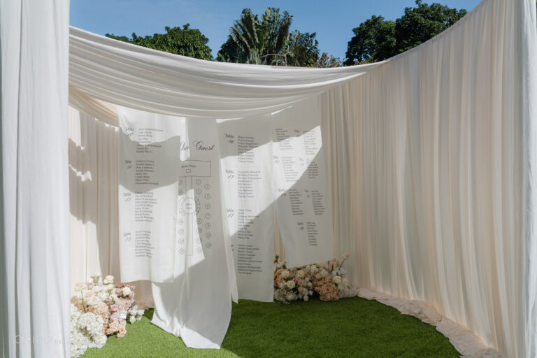 Draped pavilion with a seating chart among white florals, Bali, Axioo Bali
