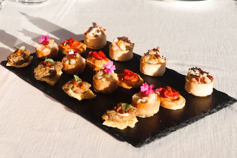 Canapes on slate, dressed with edible flowers, Baglioni Resort Cala del Porto
