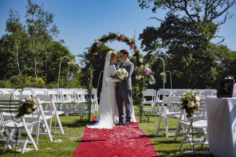 A couple at the ceremony arch on the lawn, Ballinacurra House