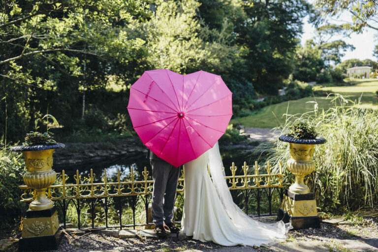 A couple under a heart-shaped umbrella in the garden, Ballinacurra House