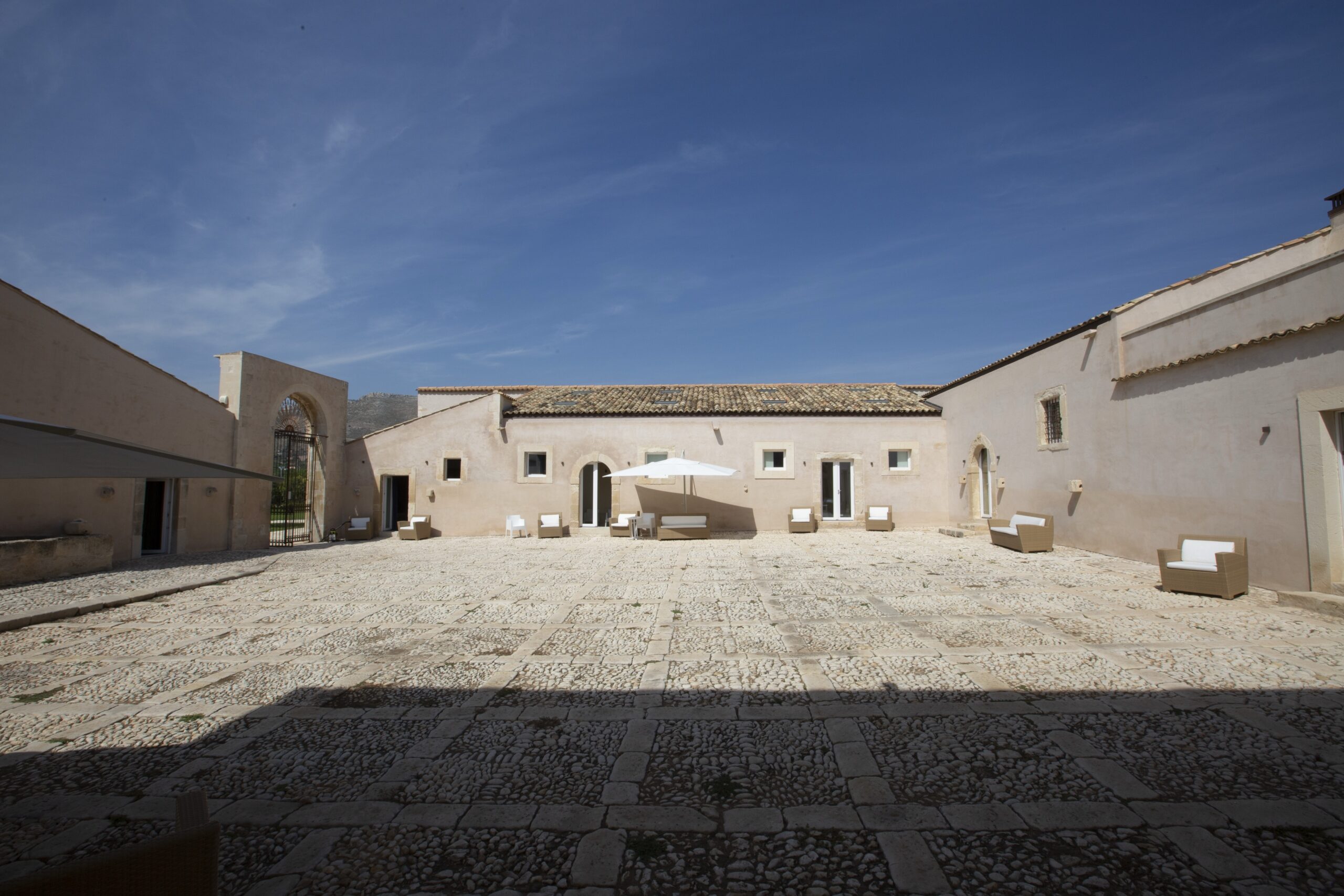 Courtyard and low buildings of the historic baglio, Ballium Luxury Relais