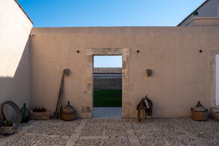 Stone doorway in the courtyard wall with farm tools, Ballium Luxury Relais