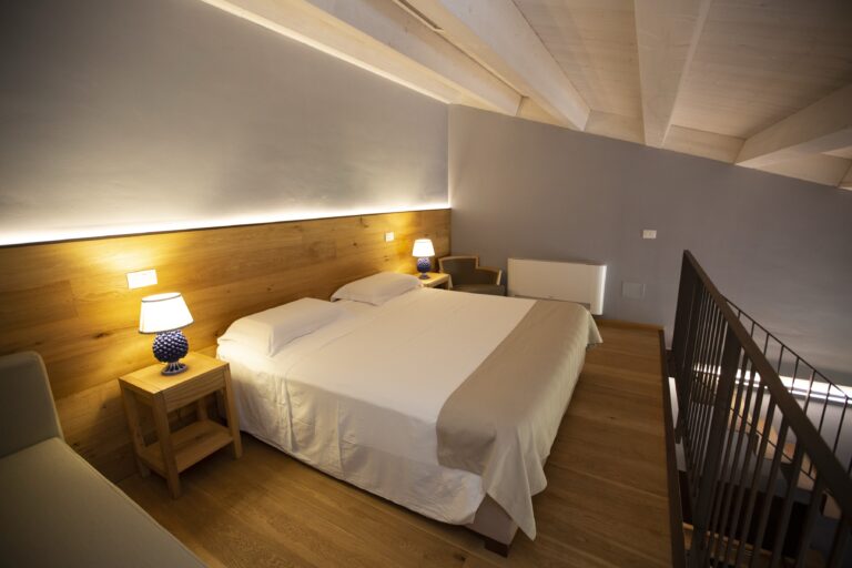 Mezzanine bedroom with timber headboard, Ballium Luxury Relais