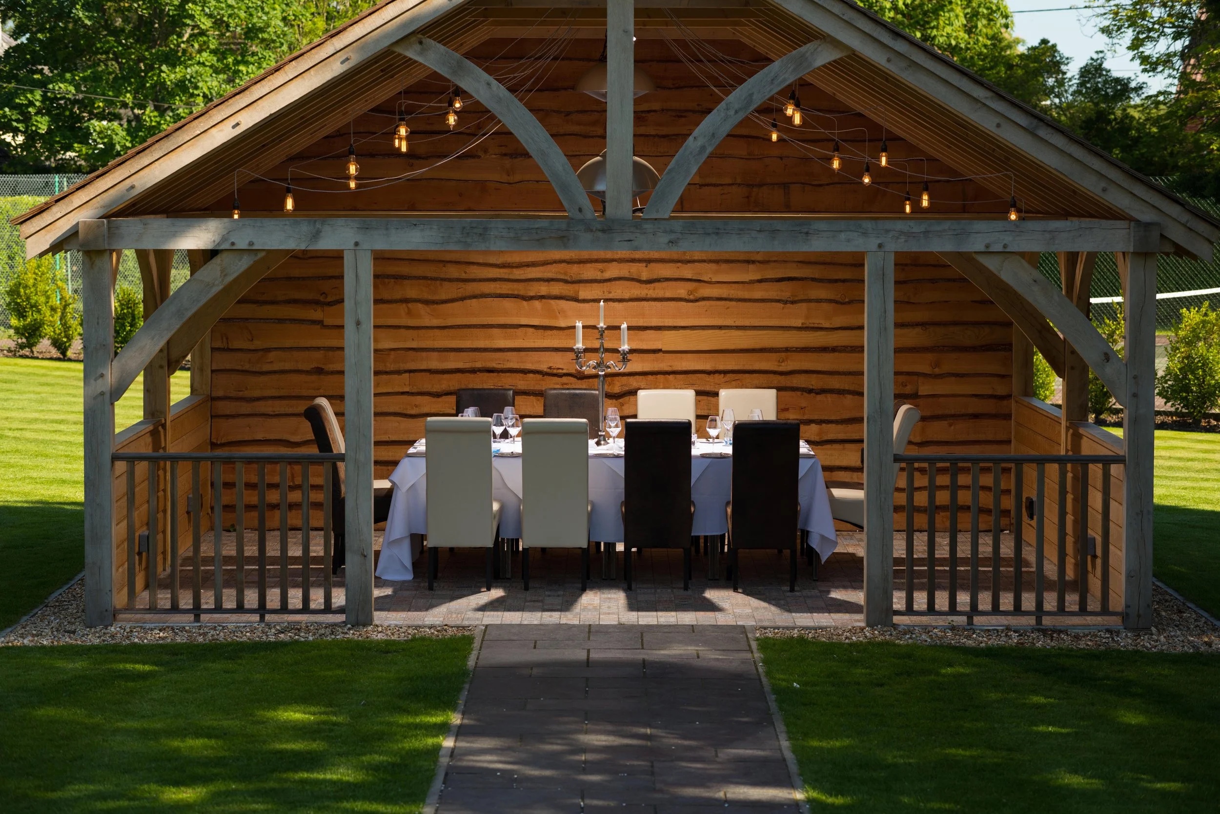 The Sylvan Pavilion on the lawn by day, with a candelabra dinner table set under its timber roof, Balmer Lawn Hotel & Spa
