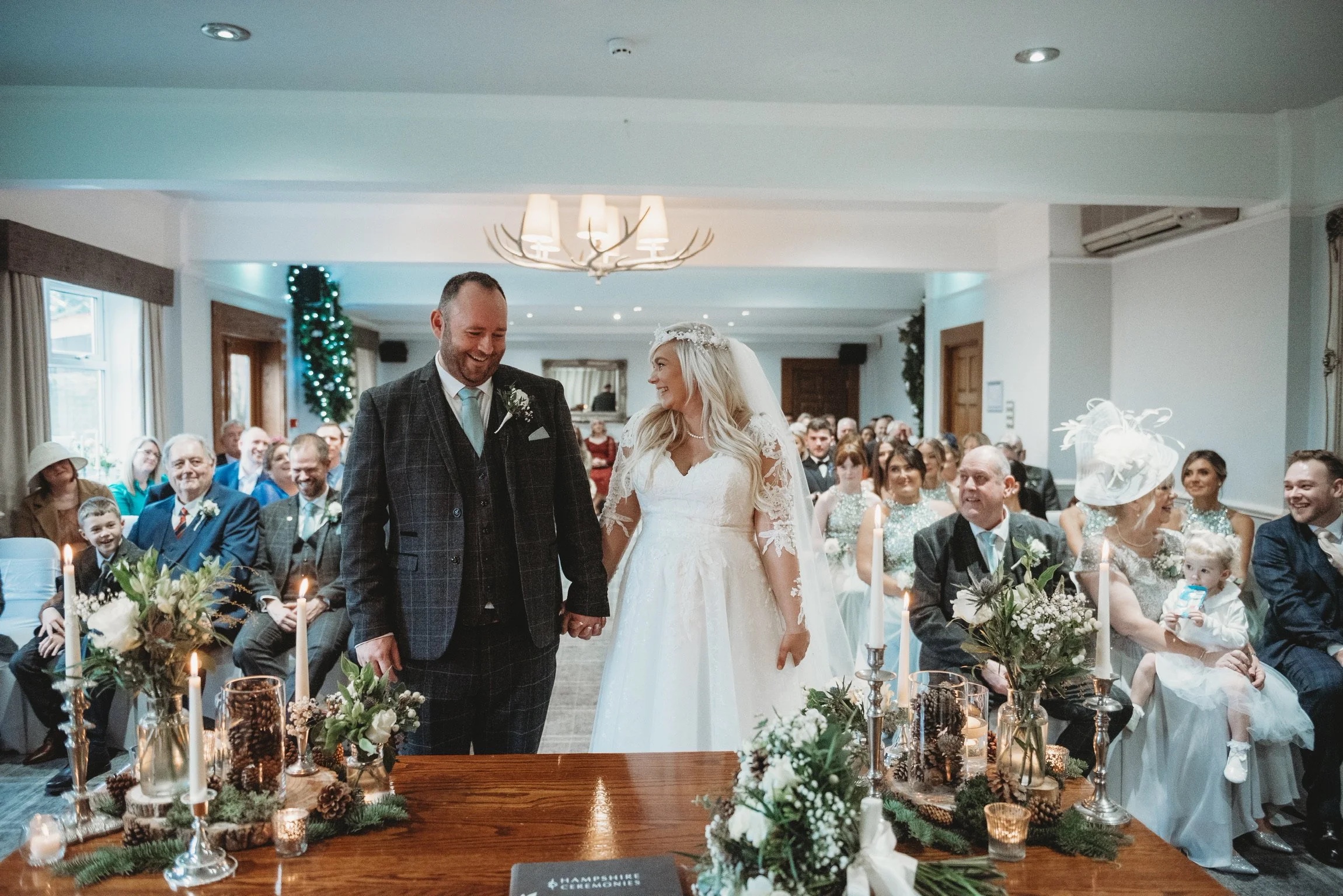 A winter civil ceremony in one of the function rooms, the couple at the registrar's table under an antler chandelier, Balmer Lawn Hotel & Spa