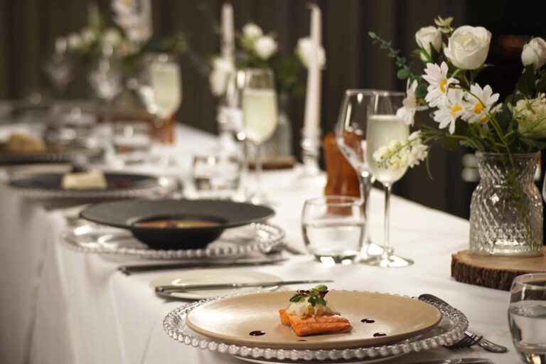 A plated fish starter on a white-clothed table with fizz, daisies and roses in cut-glass vases, Balmer Lawn Hotel & Spa