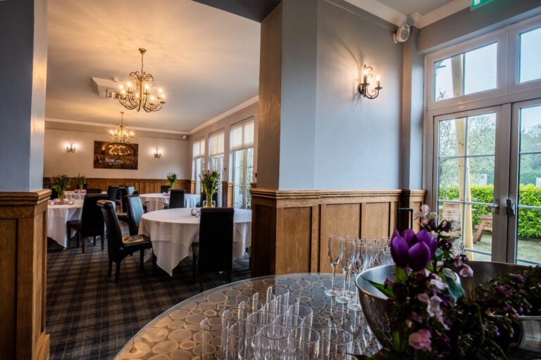 Round dining tables in the Savernake Room, glasses set out for a drinks reception by the terrace doors, Balmer Lawn Hotel & Spa
