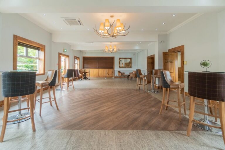 The Hamble Room cleared for an evening party, with high tables, antler chandeliers and its own bar, Balmer Lawn Hotel & Spa