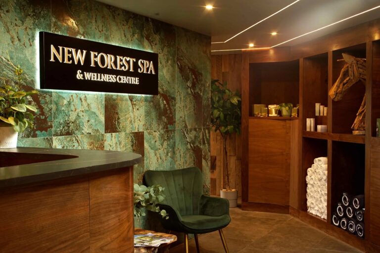 Reception of the New Forest Spa and Wellness Centre, with a green stone wall and ESPA products, Balmer Lawn Hotel & Spa