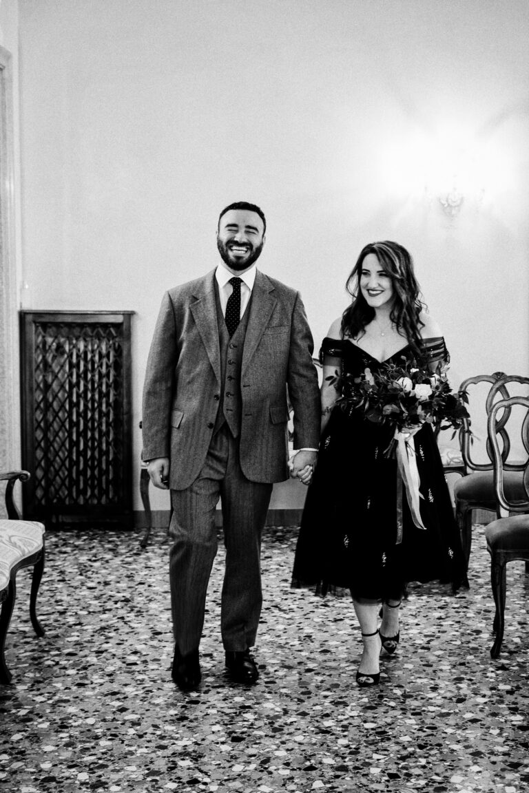 A couple walking out hand in hand after their civil ceremony at Palazzo Cavalli, Venice, Barbara Zanon Photography