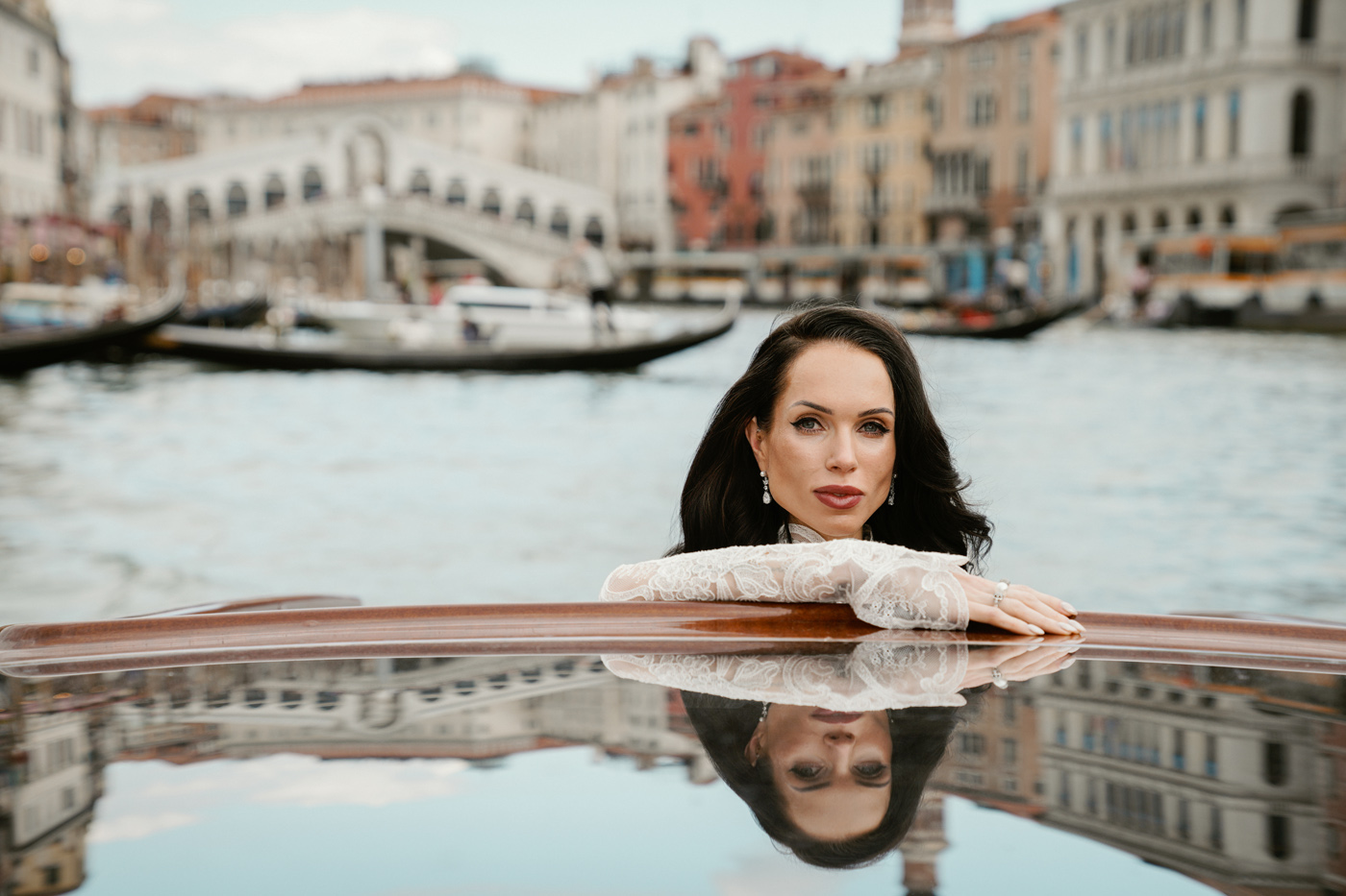 The bride leaning on a water taxi, the Rialto Bridge behind her, Venice, Barbara Zanon Photography