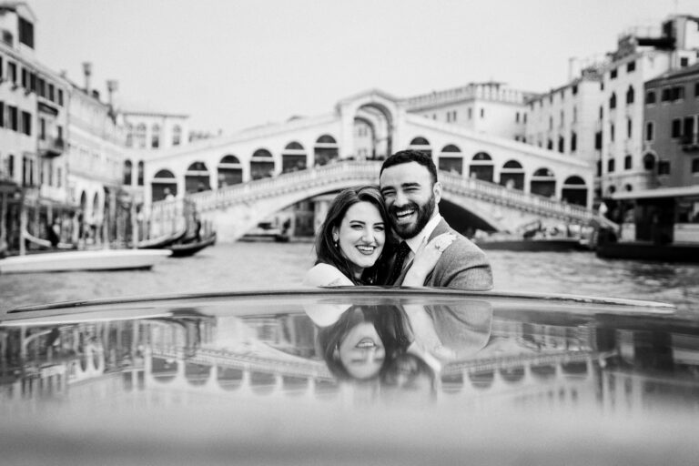 A couple reflected in the polished deck of a boat, the Rialto Bridge behind, Venice, Barbara Zanon Photography