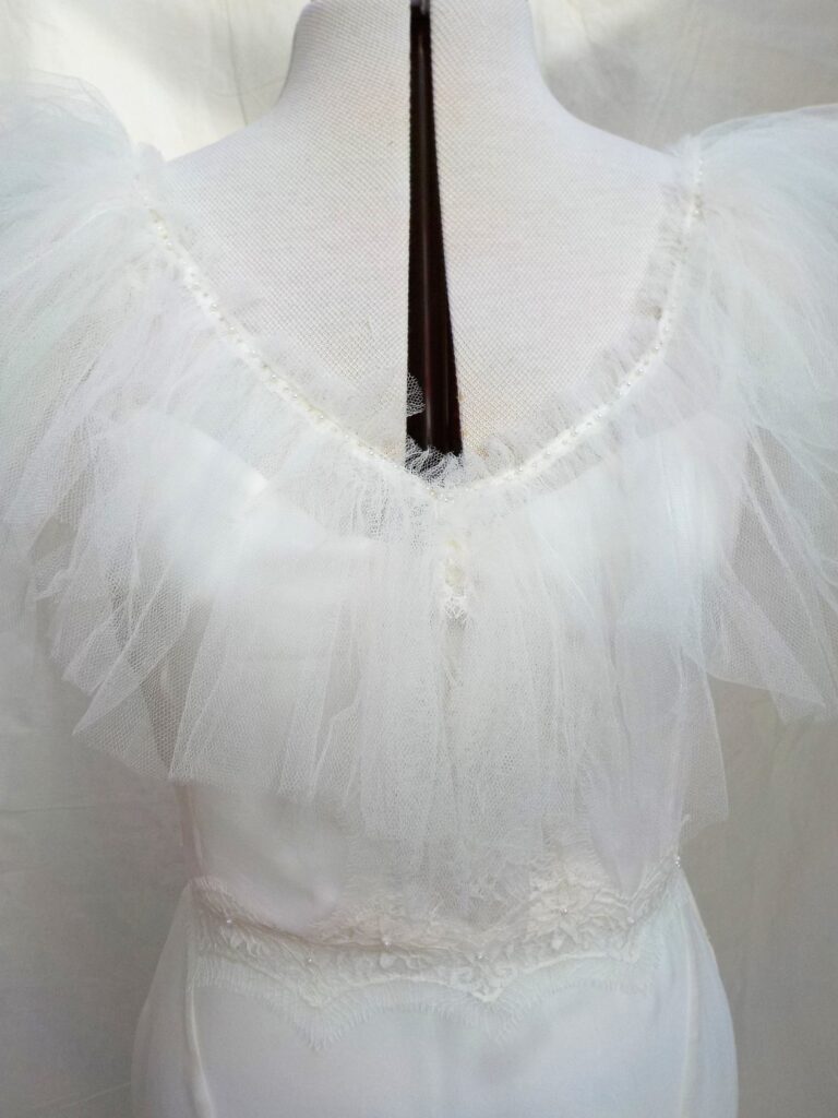 The tulle ruffle neckline of the Greta gown from the silk bridal collection, Beatrice Espinosa Bridal