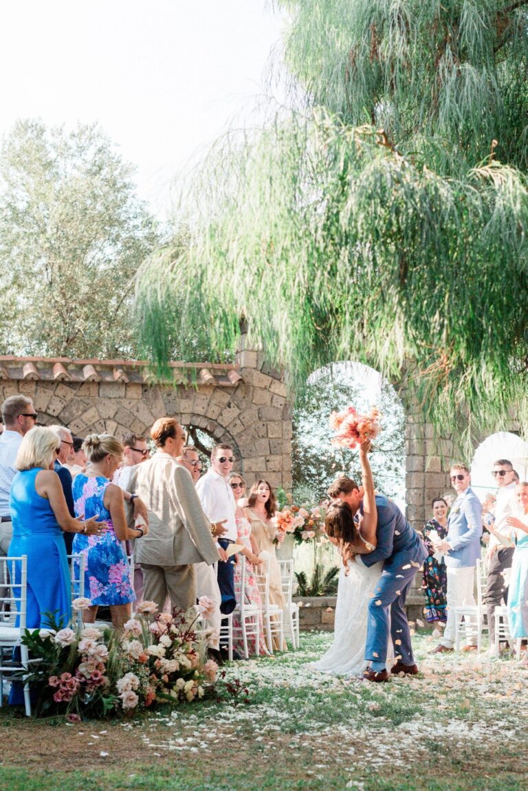 A recessional under a stone archway and a weeping willow, Bella Sposa