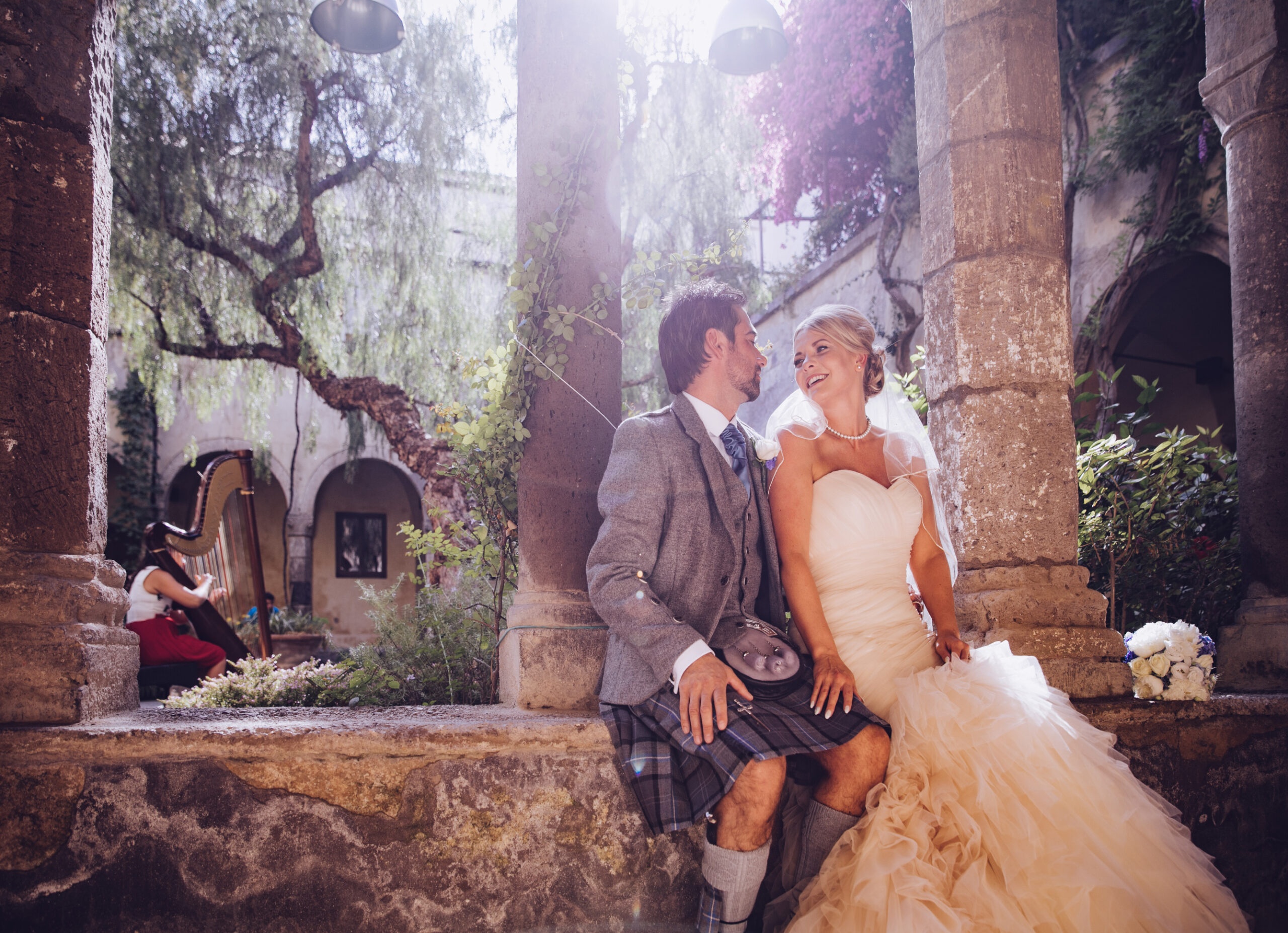 A cloistered courtyard hung with bougainvillea, a harpist playing in the arcade, Bella Sposa
