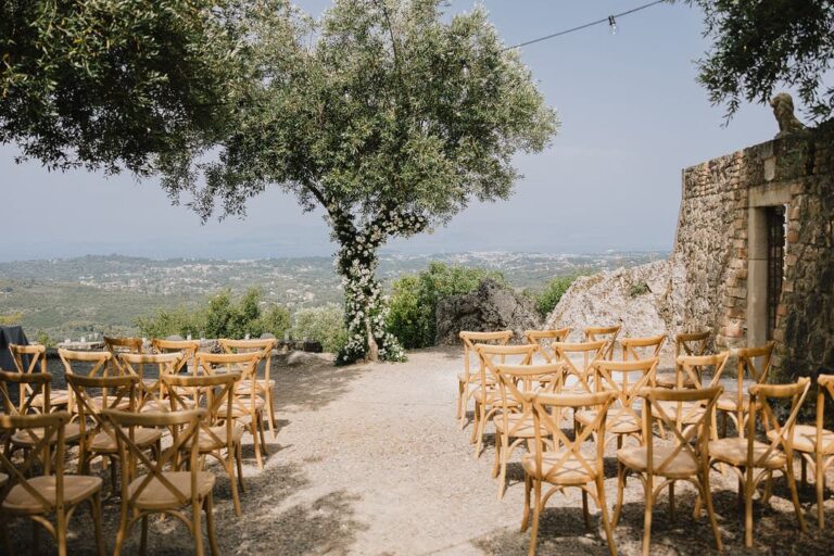 Ceremony chairs under an olive tree on a Corfu hilltop, Belli Momenti