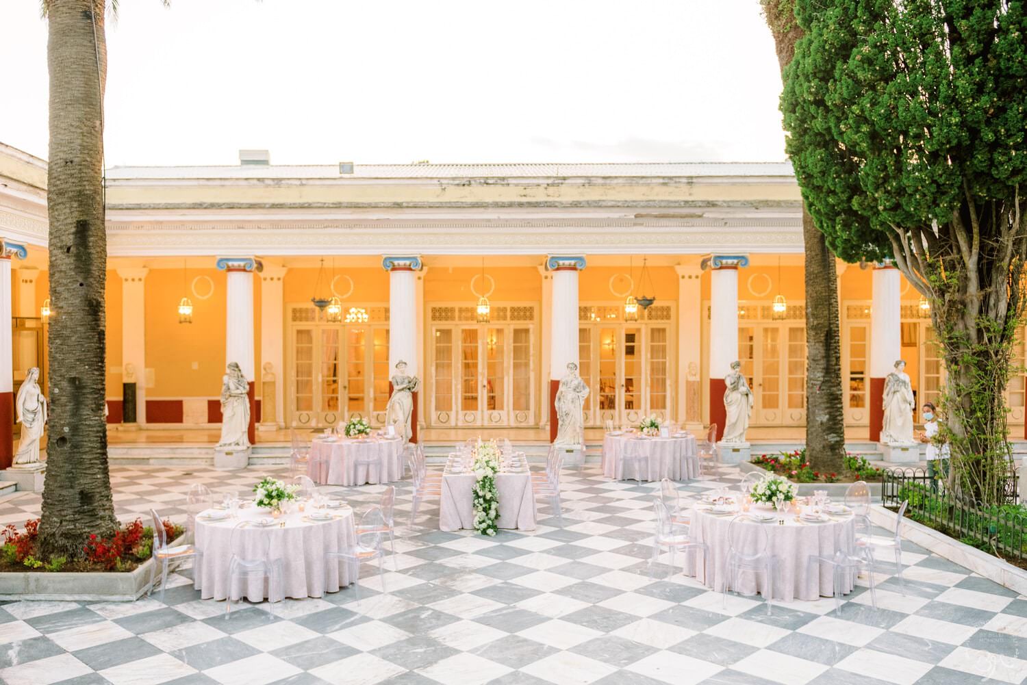 Reception tables laid on a chequered patio for a Catholic wedding in Corfu, Belli Momenti