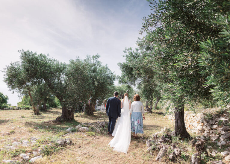 A couple walk through an olive grove in Paxos, Belli Momenti