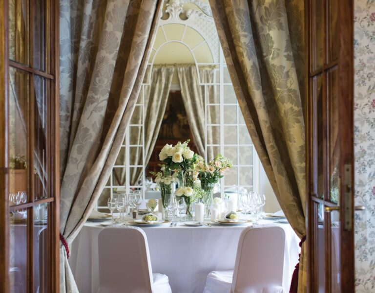 A table for guests set behind drawn drapes, Belmond Grand Hotel Europe