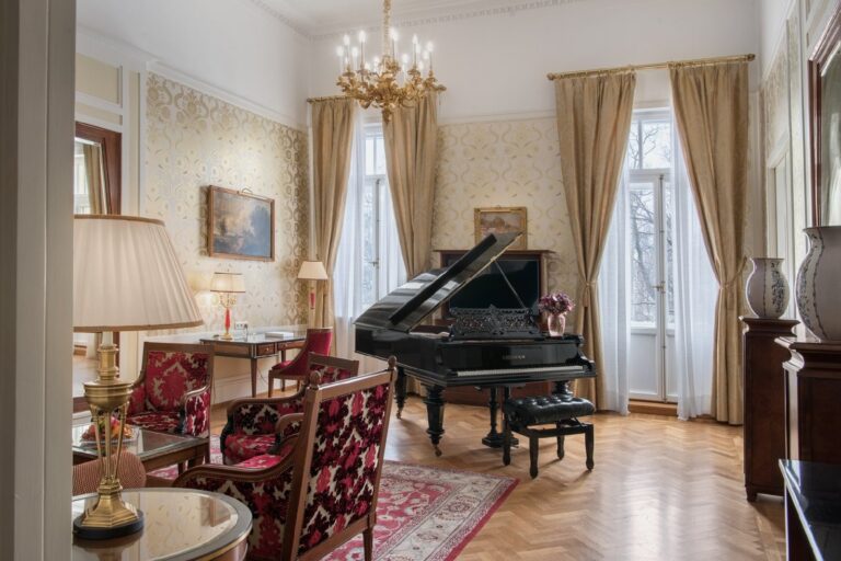 A Deluxe Historic Suite sitting room with a grand piano, Belmond Grand Hotel Europe