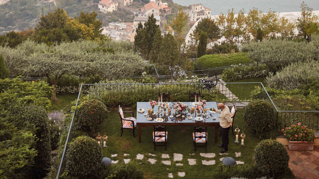 Long dining table laid in the terraced gardens, Belmond Hotel Caruso