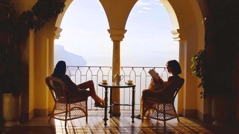Two guests seated under the arches of the terrace bar, Belmond Hotel Caruso