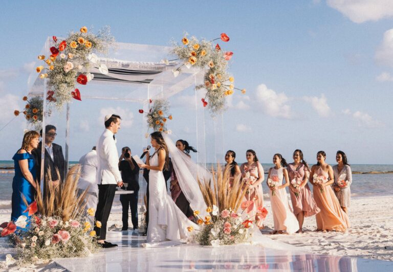 Jewish ceremony under a floral chuppah on a Riviera Maya beach, with the wedding party, Better Together Mexico