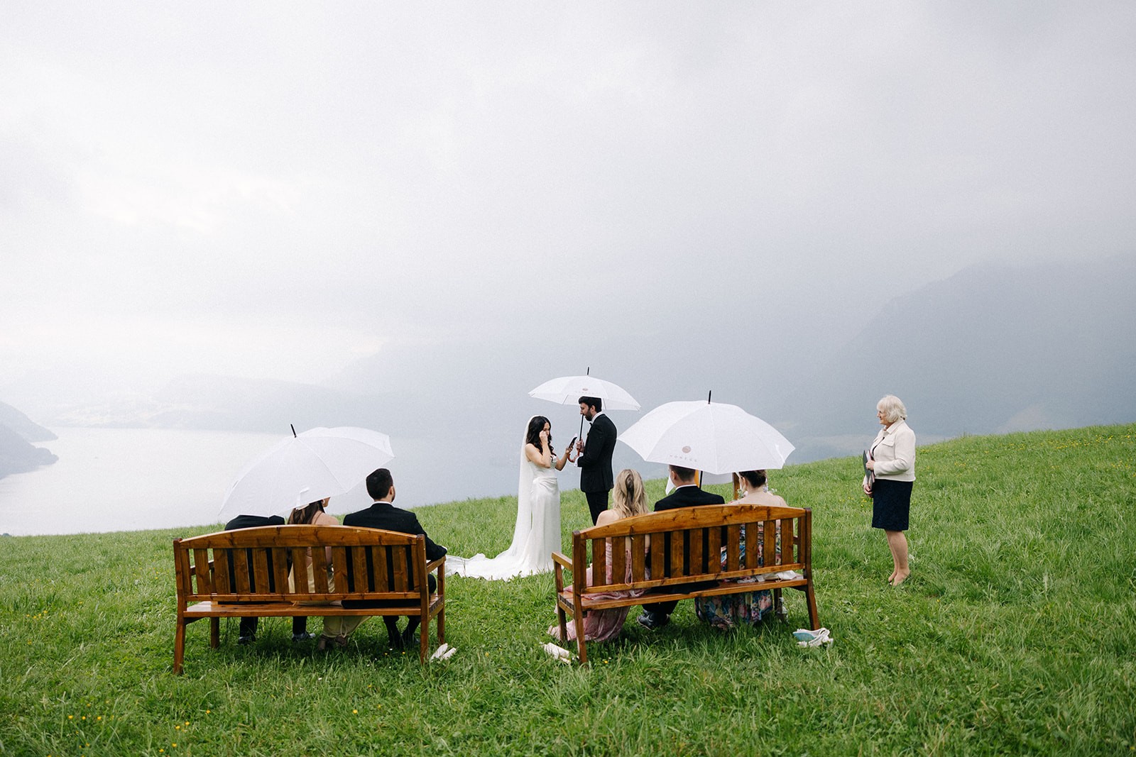 Wet-weather ceremony with umbrellas on garden benches above the lake, Villa Honegg, Bilingual Celebrant in Europe