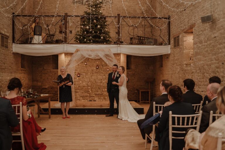 Candlelit stone barn ceremony with guests seated, Bilingual Celebrant in Europe