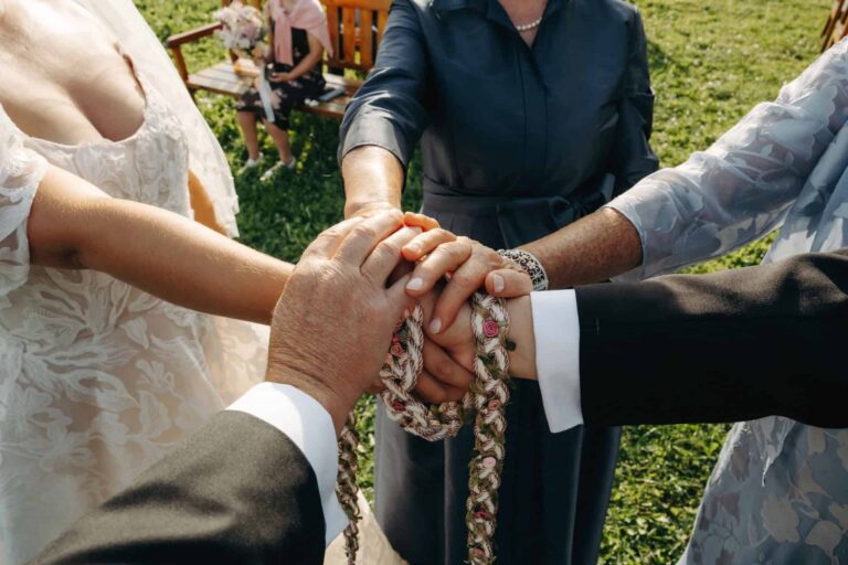 Hands joined for a handfasting at a garden ceremony, Bilingual Celebrant in Europe