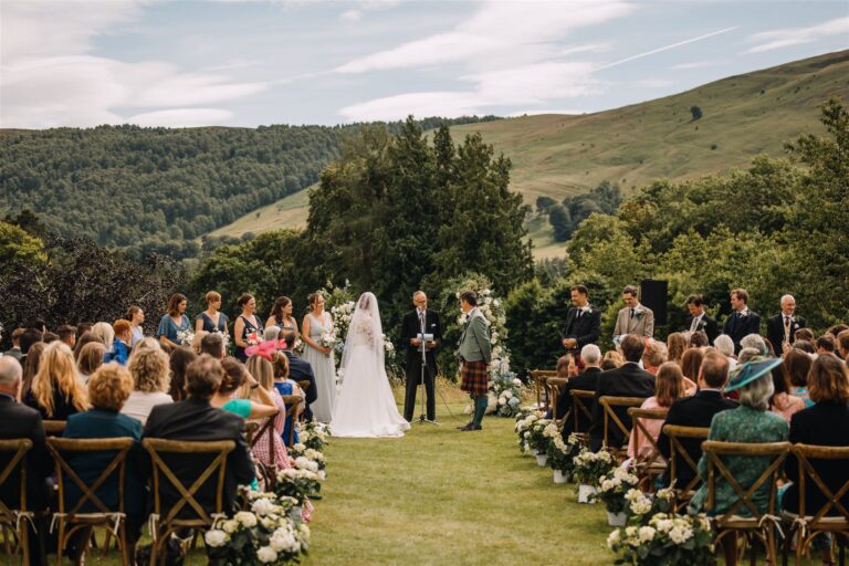 An outdoor ceremony on a lawn with wooded hills behind, Blair Castle