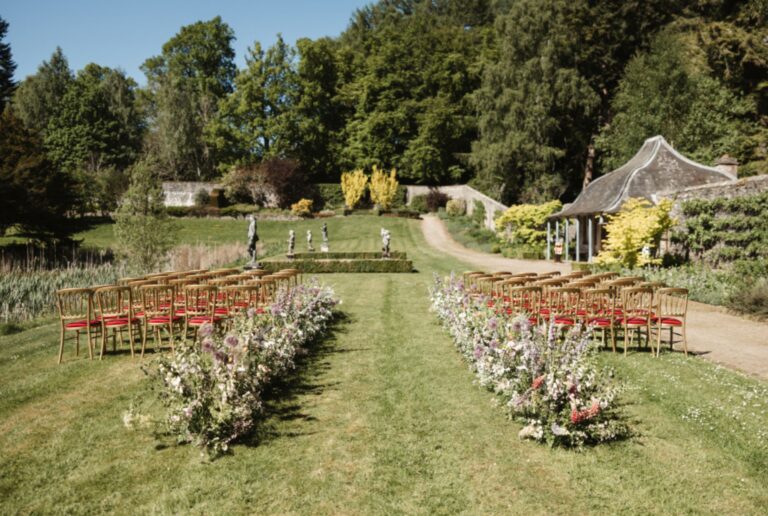 Chairs and flower-lined aisle set for a ceremony on a garden lawn, Blair Castle