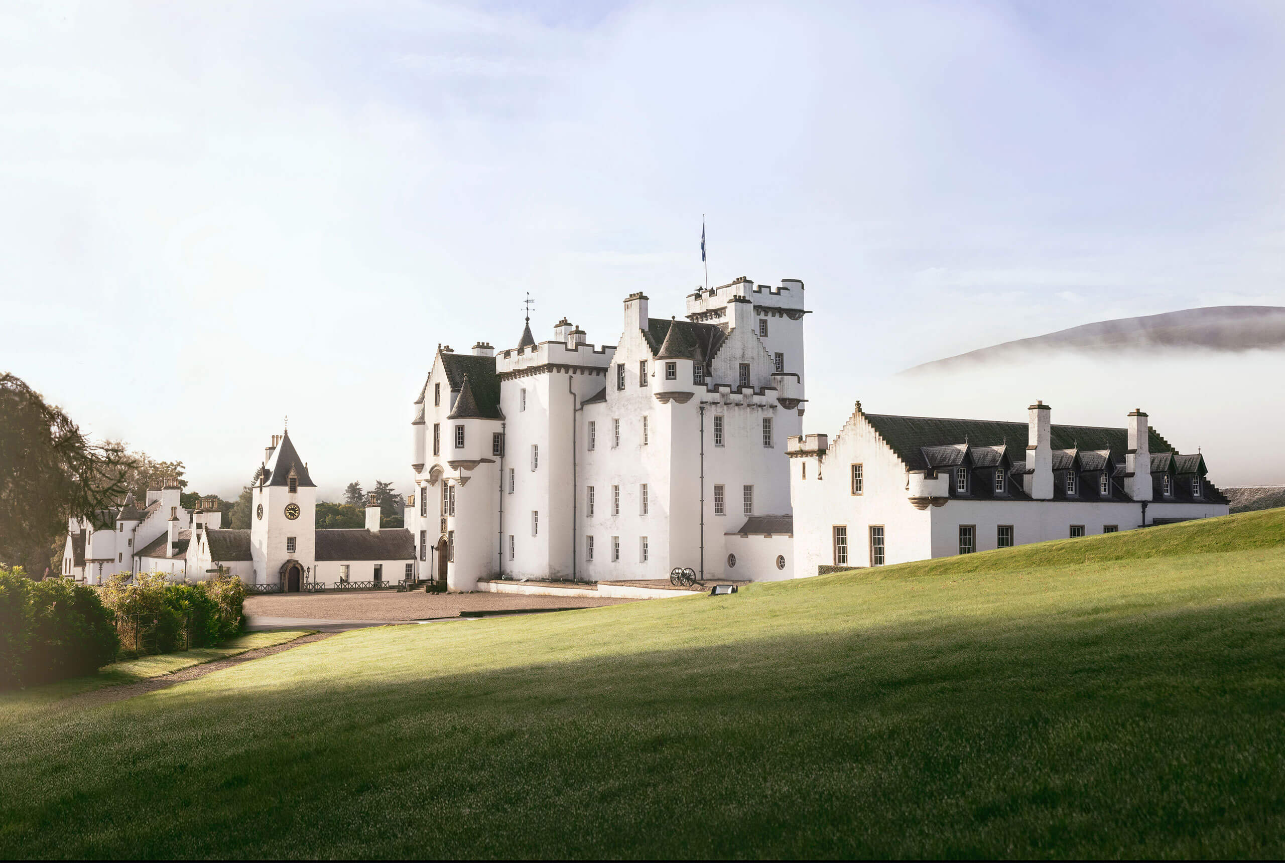 Blair Castle seen across the lawn, its white harled walls and turrets against the hills, Blair Castle
