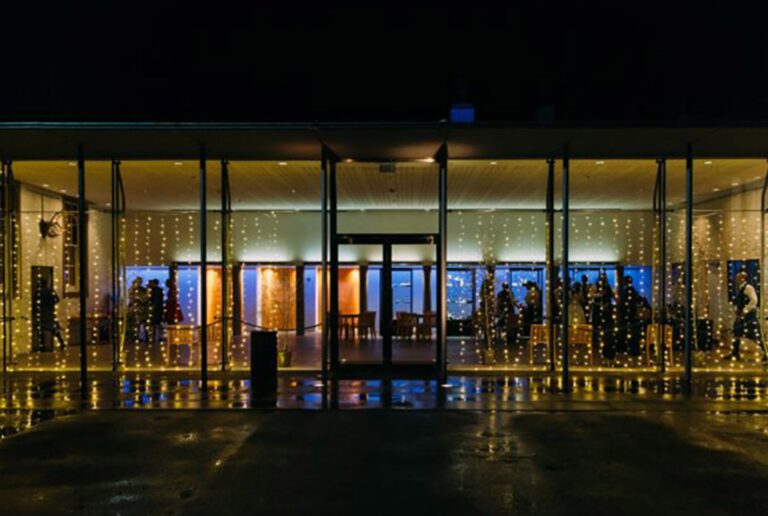 The glass front of the Banvie Hall lit up at night with fairy lights, Blair Castle