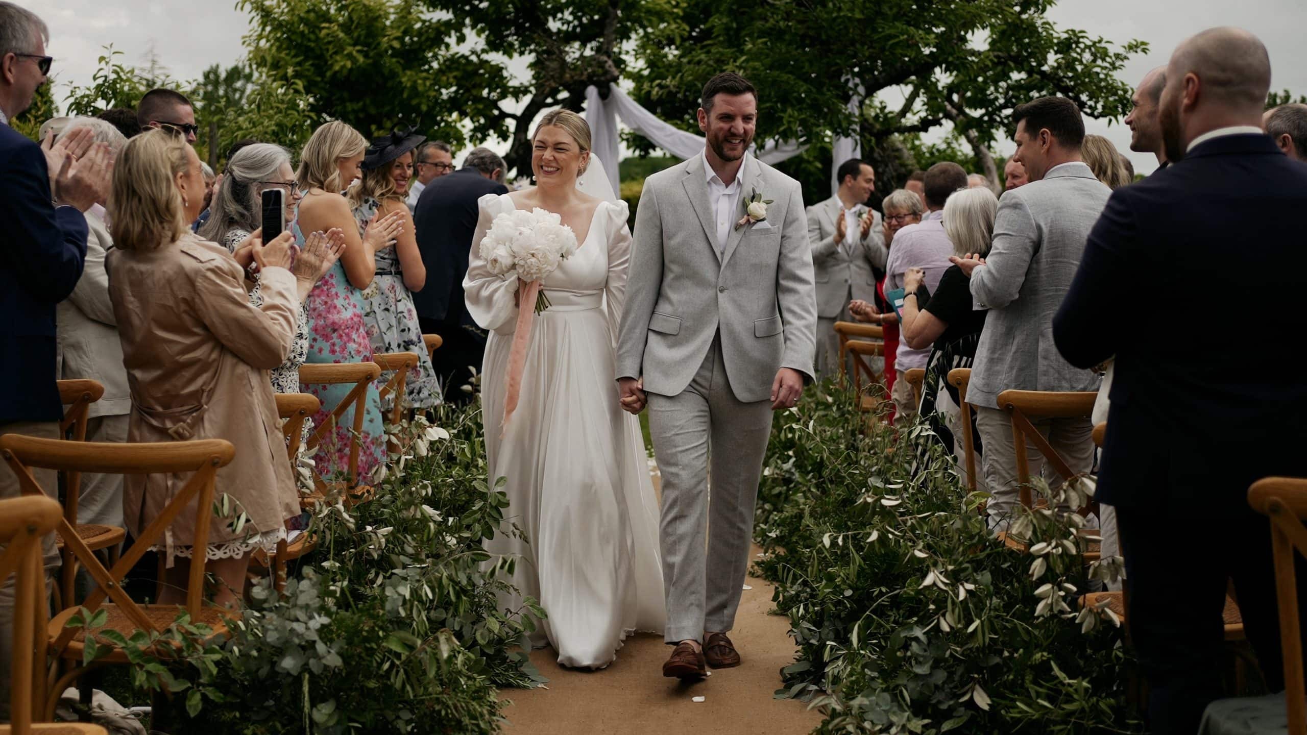 Holly and Tom walking back down the aisle after their outdoor ceremony at Manoir de Longeveau, France, Blue Ridge Films