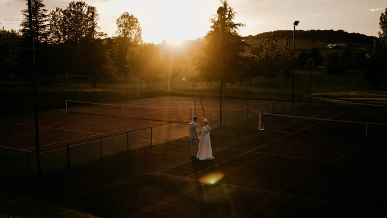 Holly and Tom on the tennis court at Manoir de Longeveau, France, as the sun goes down, Blue Ridge Films